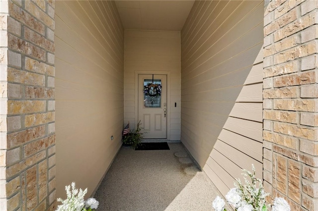 doorway to property featuring brick siding