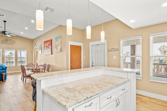 kitchen with white cabinetry, light hardwood / wood-style flooring, a center island, and pendant lighting