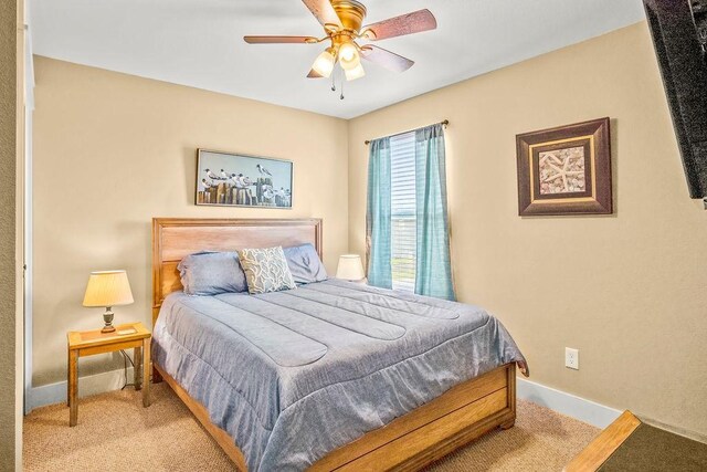 bedroom featuring light carpet and ceiling fan