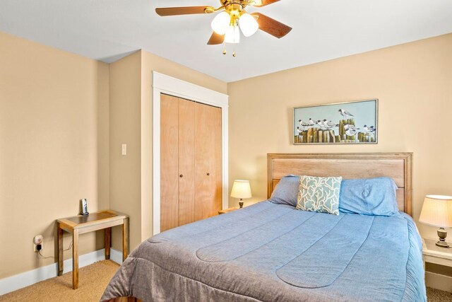 carpeted bedroom with ceiling fan and a closet