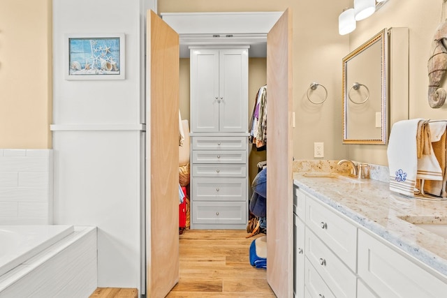 bathroom featuring a bath, vanity, and wood-type flooring