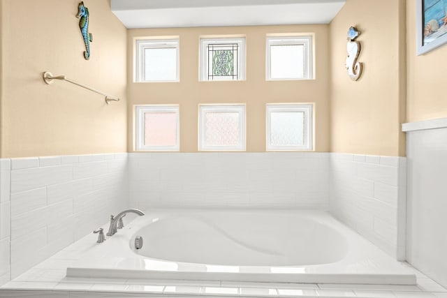 bathroom with plenty of natural light and a relaxing tiled tub