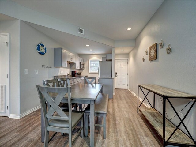 dining area featuring sink and light wood-type flooring