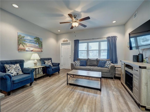 living room featuring ceiling fan and light wood-type flooring