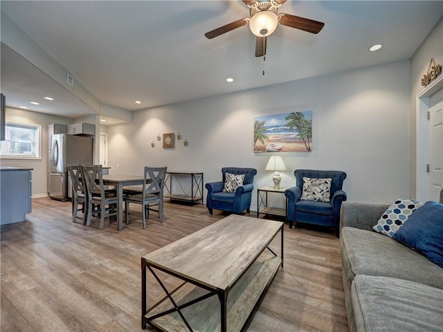 living room with light wood-type flooring and ceiling fan