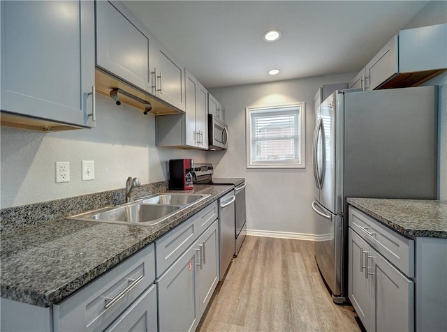 kitchen featuring gray cabinetry, sink, appliances with stainless steel finishes, and light hardwood / wood-style flooring