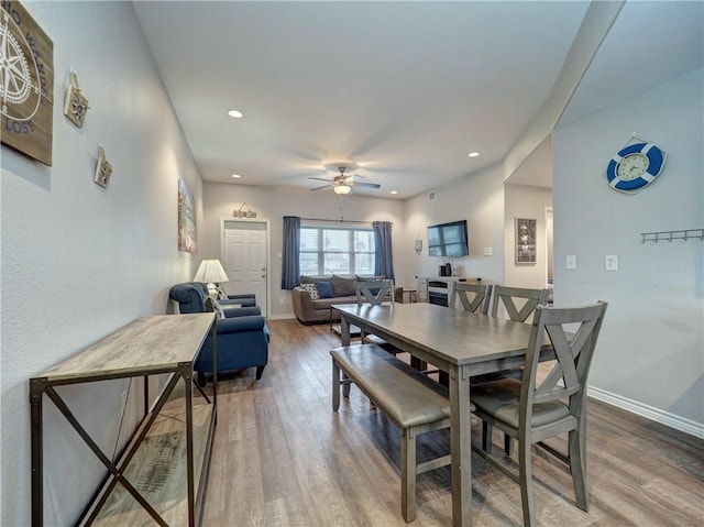 dining space with hardwood / wood-style flooring and ceiling fan