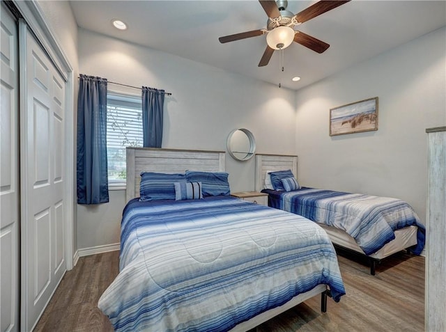 bedroom with wood-type flooring, a closet, and ceiling fan