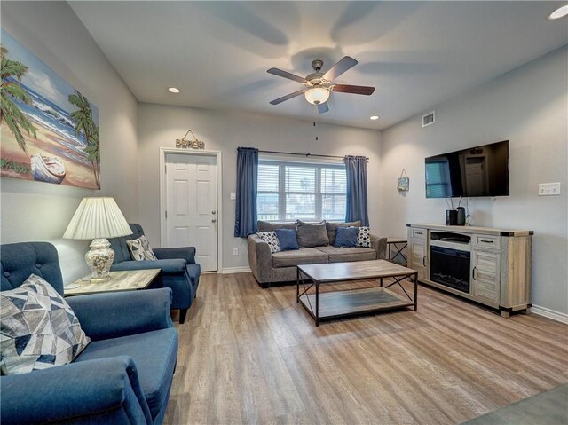 living room featuring ceiling fan and light hardwood / wood-style flooring