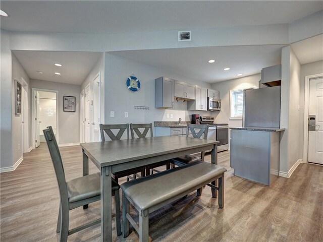 dining space with light hardwood / wood-style floors