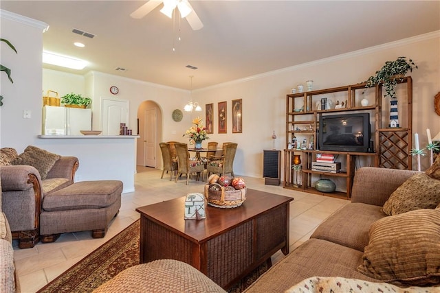 tiled living room with ceiling fan with notable chandelier and crown molding