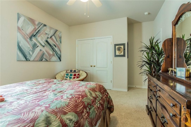 bedroom featuring a closet, light colored carpet, and ceiling fan