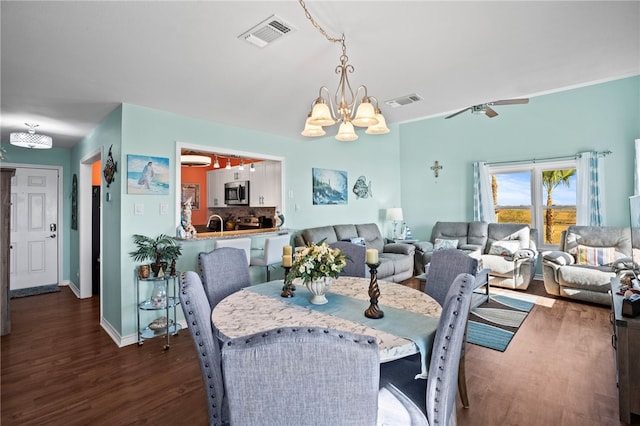 dining area featuring dark hardwood / wood-style flooring and ceiling fan with notable chandelier