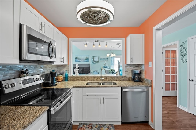 kitchen featuring appliances with stainless steel finishes, white cabinetry, stone countertops, and sink