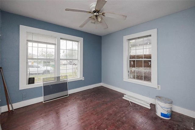 unfurnished room with ceiling fan, dark wood finished floors, and baseboards