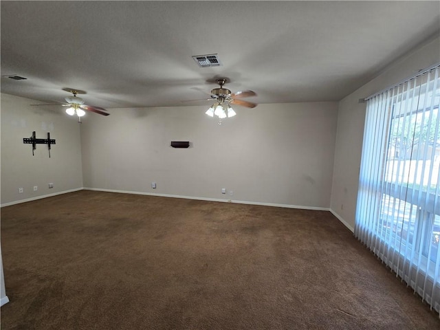 unfurnished room with carpet, visible vents, and ceiling fan