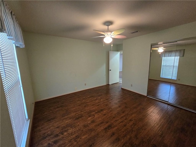 interior space with visible vents, a ceiling fan, and wood finished floors