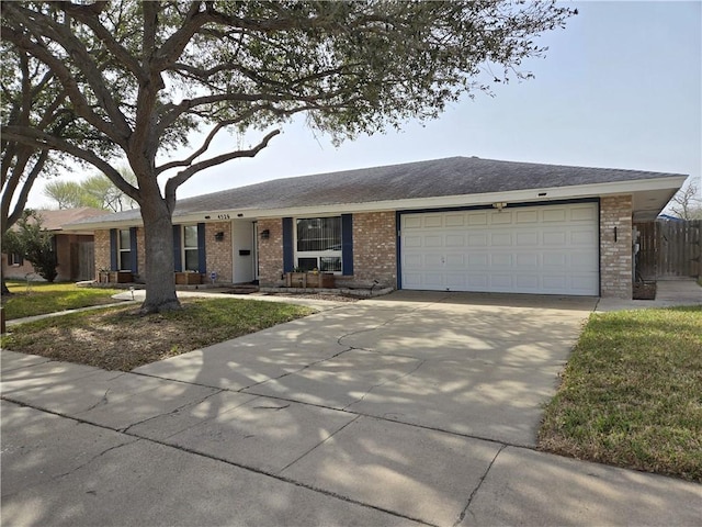 ranch-style house featuring a garage, concrete driveway, and brick siding