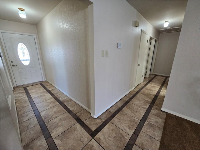 entryway with a textured wall and baseboards