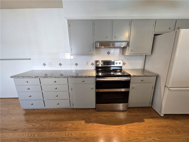 kitchen featuring under cabinet range hood, gray cabinetry, range with two ovens, and freestanding refrigerator