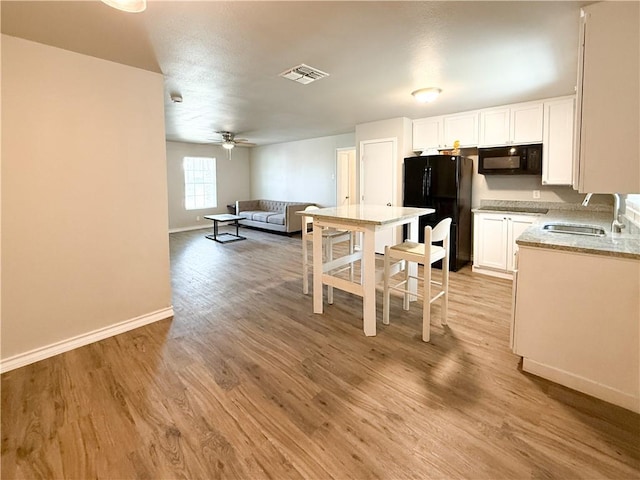1021 Dona Dr, Corpus Christi, TX 78407 - kitchen featuring a sink, black appliances, open floor plan, ceiling fan, and baseboards