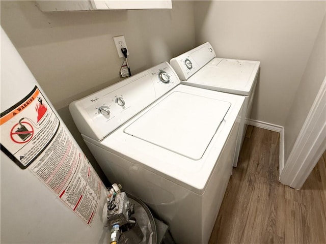 1021 Dona Dr, Corpus Christi, TX 78407 - laundry area featuring wood finished floors, washing machine and dryer, water heater, and baseboards