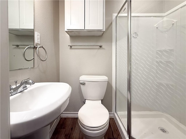 1021 Dona Dr, Corpus Christi, TX 78407 - bathroom with wood finished floors, a shower stall, a sink, and toilet