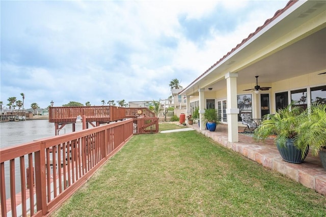 view of yard featuring a water view, a patio, and ceiling fan