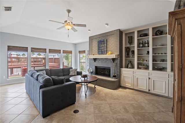 living room with light tile patterned floors, a fireplace, a ceiling fan, and visible vents