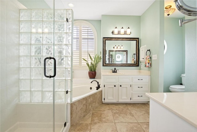 bathroom with vanity, a garden tub, toilet, tile patterned floors, and a shower stall