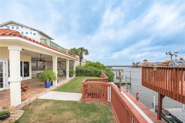 view of yard featuring a water view, ceiling fan, and a patio area