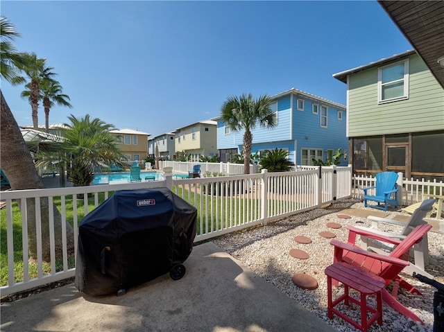 view of patio / terrace with a sunroom, a fenced in pool, an outdoor fire pit, and grilling area