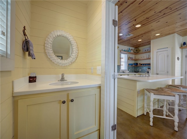 bathroom featuring wooden ceiling, vanity, and concrete floors