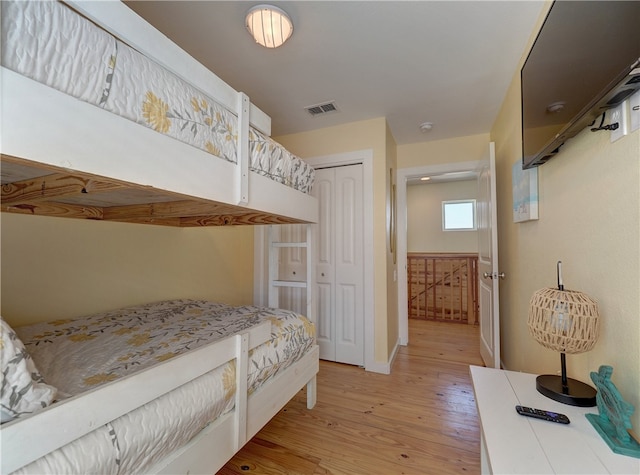 bedroom with light hardwood / wood-style flooring and a closet