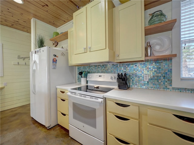 kitchen with wood walls, white appliances, cream cabinets, and decorative backsplash