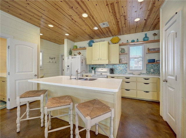 kitchen with sink, a breakfast bar, an island with sink, white appliances, and decorative backsplash