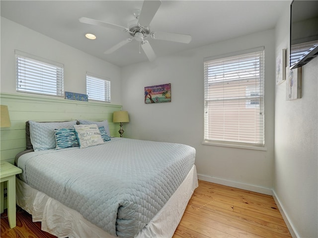 bedroom featuring light hardwood / wood-style floors, multiple windows, and ceiling fan