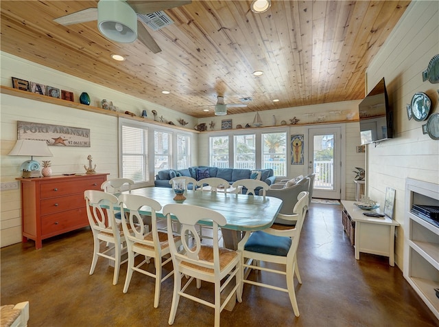 dining room featuring wood walls, wooden ceiling, and ceiling fan