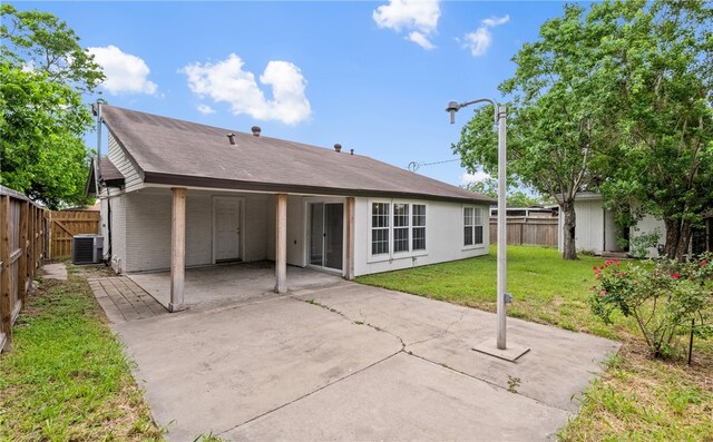 1333 Prince Dr, Corpus Christi, TX 78412 - back of property with central air condition unit, a patio area, an attached carport, and driveway