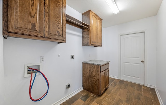 washroom featuring wood finish floors, hookup for a washing machine, hookup for a gas dryer, cabinet space, and electric dryer hookup