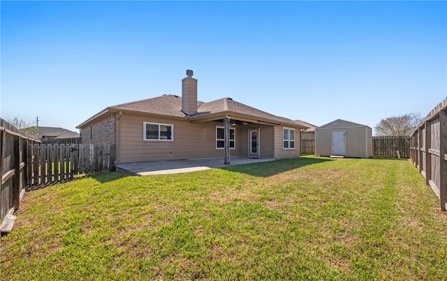 back of house featuring a patio, a fenced backyard, a yard, a storage shed, and an outdoor structure