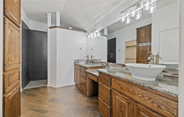 full bathroom with a sink, two vanities, and a walk in shower