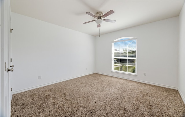 carpeted spare room with baseboards and ceiling fan