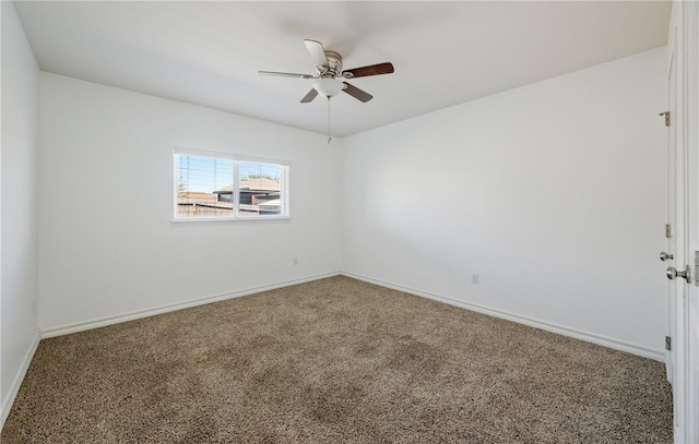 carpeted spare room with ceiling fan and baseboards