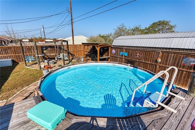 view of swimming pool with a deck, a fenced backyard, and a fenced in pool