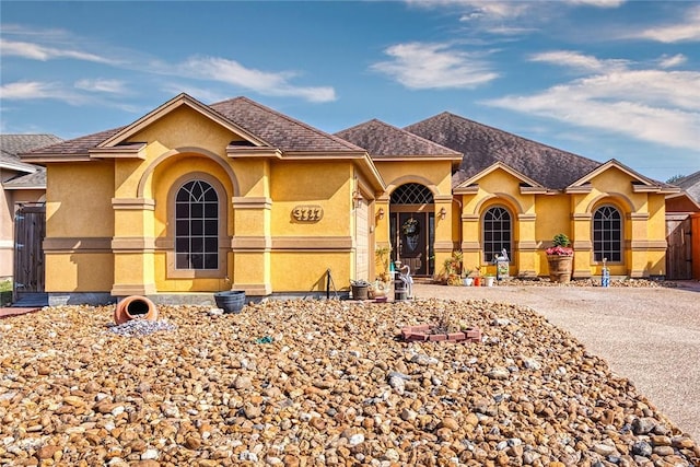 3717 Holland Dr, Corpus Christi, TX 78418 - mediterranean / spanish house featuring stucco siding, fence, and a shingled roof
