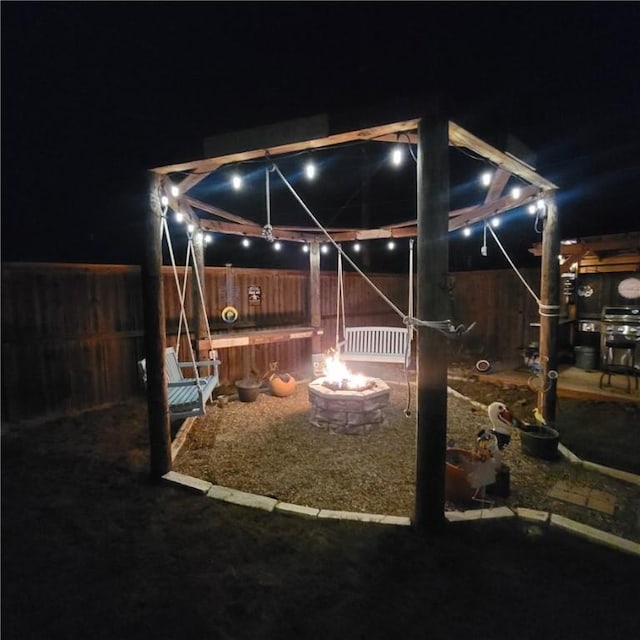 patio at night with an outdoor fire pit and fence