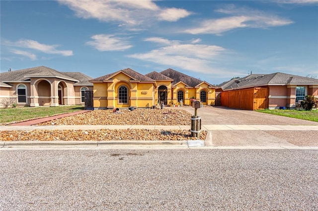 mediterranean / spanish-style home featuring stucco siding and driveway