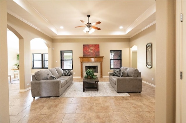 14426 Pentridge Dr, Corpus Christi, TX 78410 - living area featuring a raised ceiling, light tile patterned floors, ceiling fan, crown molding, and a fireplace