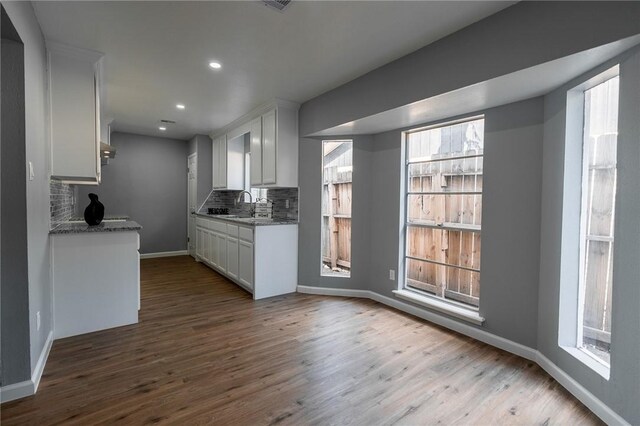 3809 Capri Dr, Corpus Christi, TX 78415 - kitchen with tasteful backsplash, dark wood-type flooring, white cabinets, baseboards, and recessed lighting